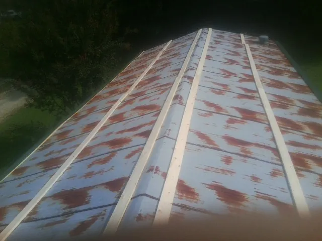 Rusted metal roof panels with new wood purlins before replacement — Storm Damage Roof Repair in Pittsville by Roofing Brothers